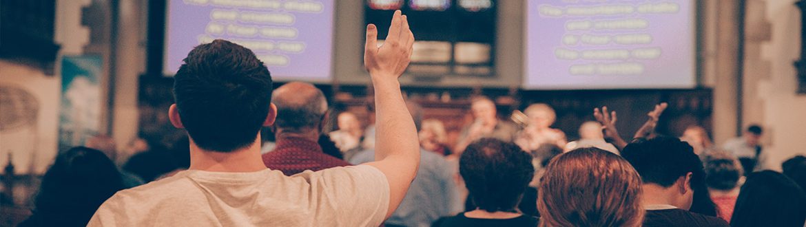 Church worshippers with lyrics projected onto big screens